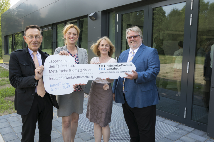 Prof. Dr. Wolfgang Kaysser, Karin Prien, Prof. Dr. Regine Willumeit-Römer, Dr. Herbert Zeisel hold a symbolic key with the inscription New laboratory building for metallic biomaterials. Institute for Materials Research